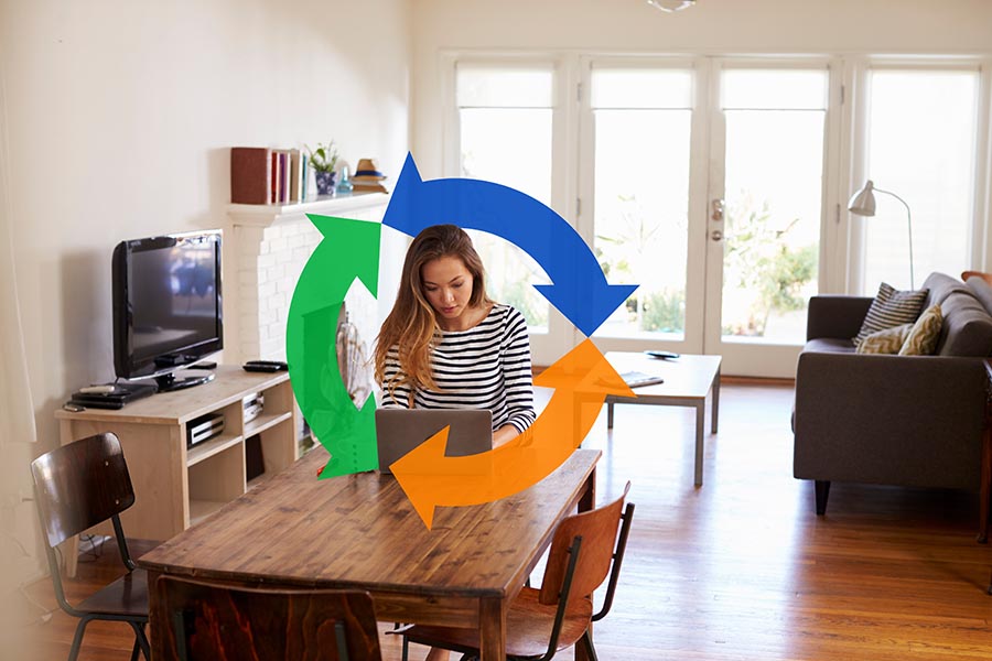 Woman sites at desk typing on laptop computer connected to fiber internet with big Conexon logo behind her.